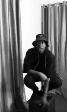This black-and-white video demonstrates how to create a music video using simple props and lighting. A performer in a bucket hat and dark clothing crouches on a block, lip-syncing and gesturing expressively to a song. The final frame reveals the phone's control center, showing the recording interface. This tutorial provides a practical, DIY approach to music video production. by @fdlsage with fdlsage by Original Sound