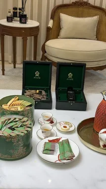 Watch Ebtihaj Al-Mutairi present a luxurious gift set from the brand 'Pione'. This elegant unboxing features exquisite green boxes, a sophisticated tea ceremony setup with delicate pastries and tea bags, and a display of high-end products including what appears to be agarwood and a fragrance bottle. The scene is set in a beautifully furnished room, creating an atmosphere of refined taste and hospitality. by @bee.8907 with Original Sound by bee.8907