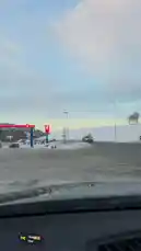 This point-of-view clip captures a journey along a snow-covered road in Norway during sunset. The camera, mounted inside a car, shows passing vehicles including a large blue Scania truck with 'Norwegian' branding. The landscape is dominated by vast white hills and a clear sky with soft orange and blue hues. The scene provides a peaceful yet dynamic look at winter travel in Scandinavia. by @zagvik with Siren🌄🤩 by Jolmh