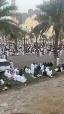 This video captures a large gathering of people at a mosque in Kuwait, many dressed in traditional white attire. As the camera pans across the scene, it reveals significant storm damage, including a collapsed metal roof structure and debris scattered throughout the area. Despite the aftermath, the crowd remains present, suggesting a communal event or prayer session taking place in the face of adversity. by @fahaad0465 with تكبيرات العيد by علي احمد الملا