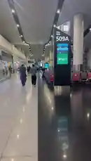This video provides a real-time look inside a bustling modern airport terminal in Saudi Arabia. The camera focuses on Gate 509A, displaying live flight information for Saudia Airlines on a large digital sign. Passengers can be seen walking through the spacious, well-lit hall, highlighting the efficient design and contemporary feel of the facility. It's a snapshot of air travel in the Kingdom. by @tr3i5 with tr3i5 by Original Sound