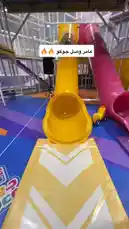 Experience the joy at جوكو للترفيه with this lively scene! Watch as a clown in a black robe slides down a vibrant yellow tube slide into a colorful indoor playground. He emerges to a crowd of excited children and adults, who cheer and reach out for high-fives. This energetic moment captures the essence of family entertainment and interactive fun. by @gioco_23 with Original Sound by gioco_23