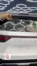 This video provides a comprehensive look at the professional car detailing process at Armor On. It begins with a close-up of a protective film being applied to a white Lexus SUV's rear window, showcasing precision work. The camera then pans out to reveal the entire vehicle, highlighting its pristine condition and modern design within the sleek, hexagon-lit detailing bay. The scene transitions inside the car, where a hand meticulously applies a clear protective film to the center console and gear shifter area, demonstrating attention to detail. Finally, the video shows the installation of a new, quilted black floor mat, emphasizing the thoroughness of the service. This showcase of Armor On's capabilities is ideal for anyone seeking top-tier protection and customization. by @armoronn with Original Sound by armoronn