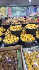 This video offers a close-up tour of a vibrant local market stall, showcasing rows of fresh dates in black plastic bowls. The camera pans across the abundant display, highlighting different varieties of dates against the colorful backdrop of other fresh produce like vegetables and fruits. A vendor can be heard speaking Arabic, praising the quality of the 'manafif' dates. This immersive look into a traditional souk experience captures the essence of local commerce and seasonal produce. by @qvalleys with Original Sound by qvalleys