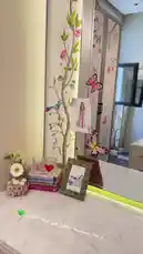 In this stylish tour of her personal space, Sabrina Carpenter showcases her beautifully curated vanity. The scene features a marble countertop adorned with a collection of perfumes, including Chanel No.5, a framed photo, books, decorative glasses, and a charming tree-themed wall mural with butterflies. She arranges her fragrance bottles neatly on a stone tray, highlighting her love for beauty and personal style. by @moneeragh with Original Sound by moneeragh