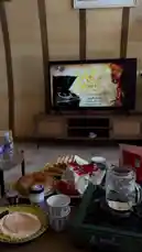 Watch a serene morning unfold in a beautifully decorated room. A spread of fresh bread, pastries, yogurt, and coffee awaits on a table beside a portable stove. In the background, a television displays Arabic calligraphy and music, setting a peaceful mood for the day. by @ab.7955 with Original Sound by ab.7955