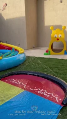 This vibrant video showcases the 'Step by Step' child care center hosting a fun-filled water day. Children are seen enjoying various activities, including playing in inflatable pools, sliding down water slides with inner tubes, and having a refreshing snack break. The scenes capture joyful moments of summer play, highlighting the center's commitment to creating an engaging and safe environment for young children. by @stepbystepkh with Original Sound by stepbystepkh