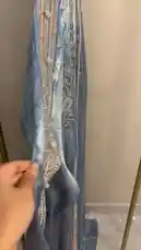 A close-up showcase of a stunning light blue abaya with intricate silver embroidery, displayed on a mannequin. The camera pans out to reveal the full garment, highlighting its elegant design and craftsmanship. by @needle_t with needle_t by Original Sound