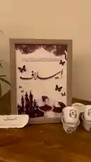 Watch as the enchanting 'Ismailaf' display from متجر ريزن تبوك🧚‍♀️ comes to life. This beautifully crafted setup, featuring a framed artwork with a fairy tale castle and delicate butterflies, is complemented by elegant white porcelain cups adorned with the letter 'E'. The scene evokes a sense of whimsy and sophistication, perfect for a special occasion. This visual masterpiece is designed to capture attention and inspire viewers. by @r200an with original sound