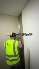 This behind-the-scenes look at 151 Constructions & General Ma's work shows a worker installing drywall in a modern apartment unit. The camera pans across a newly constructed space, revealing clean white walls, a skylight, and a large window, all in various stages of completion. The Arabic text overlay adds a humorous touch, suggesting a lighthearted moment during the build. by @construct151 with construct151 by Original Sound