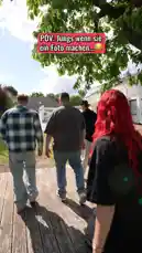 A young woman with vibrant red hair prepares to take a photo of three casually dressed young men in a sunny backyard. They pose confidently, but their expressions quickly shift to confusion and alarm as something unexpected happens off-camera, culminating in a loud crash. by @lewinray with Original Sound by lewinray