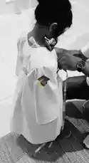 This touching black-and-white video captures a special moment where a young child is being dressed in a graduation gown and cap. An adult carefully helps the child into the academic attire, adjusting the robe and placing the miniature cap on their head. The child smiles brightly, showcasing the joy and pride of this milestone event, which is highlighted by the vibrant yellow tassel on the cap. by @stepbystepkh with Original Sound by stepbystepkh