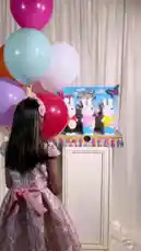 A young girl in a pink dress presents a charming collection of white bunny figurines from Joy Narcissus. Each bunny is dressed in a different colored shirt and holds a 'Happy Easter' tag. The display is set against a festive backdrop with colorful balloons and decorative fringes, creating a joyful and celebratory atmosphere perfect for the holiday. by @joy.narcissus with Original Sound by joy.narcissus