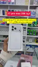 A person wearing a cast holds up a white box for an iPhone 17 Pro Max Silver model in a mobile phone store. The store shelves are filled with various other smartphone boxes. The person rotates the box to show its different sides before placing it on a glass counter next to another product box. A male voice speaks in Arabic, advertising a special offer for the device with a price of 5,799 SAR. by @mktml3 with Original Sound by mktml3