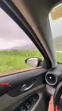 Experience a scenic drive through lush green landscapes during a rainy day from the driver's perspective inside a modern car. The journey captures the beauty of nature under overcast skies, with views of distant mountains and vibrant fields passing by. This personal vlog-style clip offers a serene yet dynamic look at a road trip adventure, enhanced by ambient sounds and the intimate feel of being behind the wheel. by @batoolmakeup1 with راسليني يالهبوب الجنوبيه by 🤍🍃