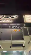 This behind-the-scenes look at Khubzia restaurant showcases their modern dining space, bustling kitchen, and delicious food preparation. Watch as they craft fresh pizzas, prepare falafel wraps, and cook skewers, all while highlighting their stylish branding. by @vg.lens with vg.lens by Contains: Until I Found You (Piano Version) - Stephen Sanchez