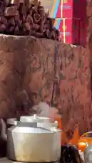Watch as a large aluminum kettle heats over an open flame, steam rising in the desert air. This authentic scene captures the essence of traditional tea preparation, a cornerstone of Saudi Arabian culture and hospitality. The rustic setting, complete with stacked firewood and Arabic calligraphy, offers a peaceful and inviting atmosphere. by @azozi.5562 with original sound