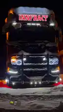 A powerful truck named 'INNFRKT' is showcased in a dramatic nighttime snowstorm. Covered in fresh snow, its custom LED lights—including a bright red illuminated sign, large headlights, and amber clearance lights—cut through the dark, creating a stunning visual effect. by @zagvik with LIFE by 🇺🇸