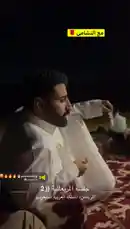 A group of men enjoy a traditional nighttime gathering in Arabia. They are seated on patterned rugs around a low table laden with tea sets and snacks. One man pours tea from a large white jug into small glasses while others relax and socialize under the night sky, with camels visible nearby. by @tr3i5 with ونعممممممم🔥🔥🔥🔥😍. by فال السعددد😍.