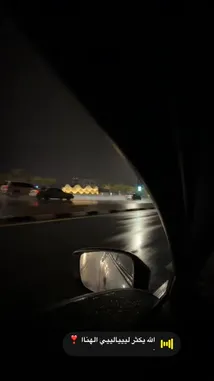 Experience the tranquil beauty of Riyadh after dark with a first-person perspective from inside a car. This immersive journey captures the city's vibrant lights reflecting off wet roads during a rain shower, creating a stunning and peaceful atmosphere. The view transitions from close-up shots of the side mirror to sweeping vistas of illuminated buildings and streets, showcasing the unique charm of the Saudi capital. by @karim.alsaleh with الله يكثر ليييالييي الهناا ❣️ by -