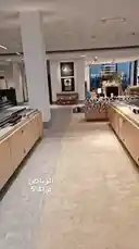 Explore the sleek interior of Alemar Concept, a contemporary lighting showroom. This walkthrough highlights a vast collection of modern light fixtures, including downlights and spotlights, displayed on minimalist wooden tables. The space features large windows offering a view of the exterior and a prominent 'Saudi Made' sign, emphasizing local craftsmanship. by @alemarconcept with alemarconcept by Original Sound