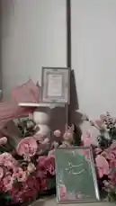 Watch as Nora presents a beautifully curated wedding day setup. This elegant display features soft pink florals, including roses and anthuriums, alongside custom Arabic calligraphy signs for 'Hatim & Mashael' dated 15.01.2026. The scene includes decorative details like a vintage calendar, crystal glasses, and delicate tea cups, all arranged on a pristine white tablecloth. The overall aesthetic is romantic and sophisticated, perfect for inspiration. by @vg.lens with vg.lens by Original Sound