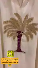 Watch this stunning white abaya being showcased, featuring a beautifully hand-embroidered palm tree motif with golden threads and purple detailing. The full-length garment is displayed on a hanger, highlighting its flowing silhouette and intricate craftsmanship. This piece exemplifies traditional elegance combined with modern design, perfect for special occasions. by @needle_t with original sound