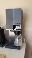 Watch as a sleek, modern coffee machine automatically brews fresh iced coffee into a glass carafe filled with ice cubes. This step-by-step demonstration shows the entire process, from water dispensing into the filter to the final pour, perfect for anyone looking to make a refreshing cold brew at home. by @alysf90 with Original Sound by alysf90