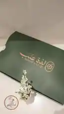 Discover Ladhat Eanab's exquisite mezze platter in this visually captivating tour. The video meticulously showcases their premium packaging, featuring the brand's elegant logo and Arabic calligraphy. It then opens to reveal a lavish spread of authentic Lebanese appetizers, including golden-brown fried items like sambusa and kibbeh, tender grape leaves stuffed with rice and herbs, and savory rolled pastries. The presentation highlights the freshness and quality of each dish, making it an enticing option for those seeking delicious, ready-to-enjoy Lebanese cuisine. by @la_ea10 with Original Sound by la_ea10
