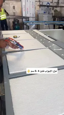 Watch a professional installer demonstrate the precise application of sealant along the edges of insulation panels in a manufacturing setting. This detailed, hands-on tutorial shows proper technique for ensuring a secure, weather-tight seal during panel assembly. A worker in a patterned shirt carefully applies white sealant using a caulking gun, while another worker in a safety vest operates equipment in the background. The process highlights best practices for sealing and joining large foam boards, offering valuable insight for anyone involved in construction, building insulation, or DIY projects. by @fula_kh with fula_kh by Original Sound