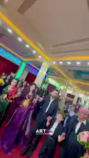 This vibrant scene captures a traditional cultural celebration featuring a group of people dressed in elaborate, colorful attire performing a synchronized dance. The setting is an ornately decorated hall with intricate ceiling designs and warm lighting, suggesting a festive occasion such as a wedding or festival. Participants, including men, women, and children, clap rhythmically and move gracefully, embodying joy and community spirit. The atmosphere is lively and celebratory, highlighting the beauty of shared traditions. by @artvideo.me with artvideo.me by Original Sound