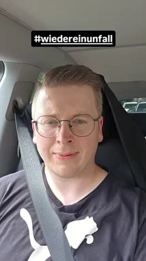 A man in a car, wearing glasses and a Puma shirt, recounts his frustration after encountering yet another accident on his daily commute. He mentions it's the same location as the previous day, leading to a one-hour delay. With the hashtag #wiedereinunfall, he shares a relatable moment of modern commuting struggles. by @itsluckymike with Original Sound by itsluckymike