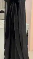 A woman models a stunning black abaya from MSNAR, showcasing its elegant design and sparkling details. She turns gracefully to display the full length and flowing fabric of the traditional garment. by @msnarabaya with Original Sound by msnarabaya