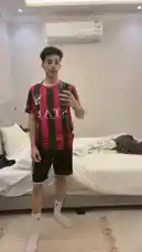 Watch Inam Sultan showcase his outfit in a bedroom mirror selfie. He's wearing a red and black striped jersey with 'STAR' printed on it, paired with black shorts and white socks. The video captures him posing and adjusting his look, providing a full view of the ensemble. by @by.sul with by.sul by Original Sound