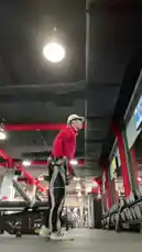 A man in a red jacket and black pants performs a series of dumbbell exercises in a modern gym. He executes bicep curls, shoulder presses, and tricep extensions with proper form, demonstrating a comprehensive strength training session. The well-lit space features red structural beams and various fitness equipment, creating an energetic atmosphere for a focused workout. by @by.sul with by.sul by Original Sound