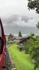 Experience a breathtaking journey aboard a red train winding through lush green hillsides beside the turquoise waters of Lake Lucerne. The route passes charming Swiss villages nestled against mist-covered mountains, showcasing the iconic beauty of Central Switzerland. This immersive point-of-view footage captures the serene atmosphere and stunning alpine landscapes perfect for travel inspiration. by @sahab-alalam with sahab-alalam by Contains: سورة السجدة كاملة - Abdel Rahman Musad -  عبدالرحمن مسعد