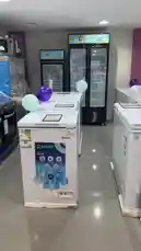 A hand points out a 'MEGA SALE' price tag of 499 SAR on a white NADCO chest freezer. The person then opens the lid to reveal the empty interior. In the background, a salesperson can be heard speaking Arabic, mentioning the freezer's size and price. by @dalilnet with Original Sound by dalilnet