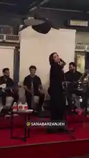 A captivating live music performance unfolds on a red-carpeted stage. A female singer in an elegant black dress delivers a passionate vocal set, backed by a band including a clarinetist and a drummer. The atmosphere is electric until a fan surprises her by presenting a large bouquet of pink and yellow flowers. The singer beams with joy, holding the flowers while continuing her song, creating a heartwarming moment of connection between artist and audience. by @mexphotographer with Original Sound by mexphotographer