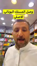 A man, identified as عطار الكويت, showcases a box of Amaa Moutxil Xou tea in his well-stocked spice shop. He holds the product close to the camera, allowing viewers to see its details while discussing it. The background reveals shelves filled with various spices, teas, and other goods, highlighting the store's extensive selection. by @fahaad0465 with Original Sound by fahaad0465