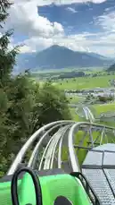 Experience the breathtaking views from a gravity-powered mountain ride in Austria. This first-person perspective captures the exhilarating speed and winding tracks as you glide through lush green valleys and past picturesque towns, all beneath majestic mountains and a dramatic sky. by @sahab-alalam with sahab-alalam by Original Sound