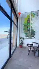 This video provides a quick tour of the interior of FOX Café, showcasing its modern design, comfortable seating, and festive decorations for Eid Al Adha. The camera moves through the space, highlighting a prominent sheep-themed display with Arabic and English text ('Eid Al Adha Mubarak'), a stylish barista station, and contemporary furniture, all set to relaxing background music. by @fox_cofee with original sound