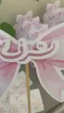 A close-up showcase of beautifully crafted pink gift boxes from 'قرطاسية سما ⭐️'. These elegant party favors feature charming floral patterns, delicate paper bows, and personalized Arabic calligraphy, perfect for celebrations like baby showers. by @rubaaomaar with Original Sound by Contains: Benti - Farah Chreim