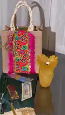 Watch as JOY NARCISSUS presents a beautifully curated gift set. This elegant display features a unique jute tote bag adorned with vibrant, colorful embroidery and intricate gold Arabic calligraphy. Alongside it, a stunning yellow glass vase, a traditional green prayer bead necklace, and other decorative items are artfully arranged on a dark green velvet cloth. The entire composition highlights exquisite craftsmanship and cultural artistry. by @joy.narcissus with Original Sound by joy.narcissus