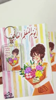 A close-up showcase of charming Teacher's Day gifts from متجر ريزن تبوك. The video highlights personalized keychains and greeting cards featuring a lovely illustration of a woman holding flowers, adorned with 'Happy Teacher's Day' in English and Arabic text. These thoughtful items make perfect presents for educators. by @r200an with original sound