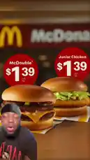 A man in a black shirt and head covering reacts with surprise and excitement to a McDonald's advertisement showing both the McDouble and Junior Chicken for just $1.39. He gestures animatedly, seemingly discussing the value of the deal. by @marvedtv with Original Sound by marvedtv