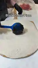 Watch as a chef demonstrates how to make a delicious black garlic pizza from scratch. Learn how to spread the unique black garlic sauce and add shredded cheese for a gourmet twist on a classic dish. by @marvedtv with Original Sound by marvedtv