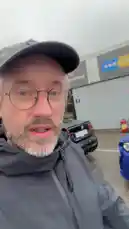 A man in a grey cap and jacket stands in a wet parking lot at Falkenbergs Spårbanor, introducing a BMW M Experience event. He gestures towards a lineup of high-performance BMWs, including blue and green models, as he speaks about driving the M3 and M2 on the track for the day. by @tershine with Original Sound by tershine