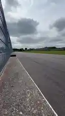 This dynamic clip captures the thrilling speed of a car racing down a professional track under an overcast sky. With the sound of a powerful engine roaring as it passes, the footage offers an immersive, first-person perspective of the action. by @tershine with Original Sound by tershine