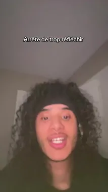 A close-up shot of Ipposen, a young man with long curly hair and a black headband, speaks directly to the camera. He gestures emphatically while delivering a message in French, with the text 'Arrête de trop réfléchir' (Stop overthinking) displayed at the top of the screen. His expressive face and direct engagement suggest he is sharing advice or a personal philosophy. by @ipposen.snap with ipposen.snap by Original Sound
