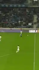 A soccer player in a white jersey slides on the grass during a match, followed by a surreal scene of a person in dark clothing tumbling through a long, narrow garden path filled with glowing embers at sunset. by @omofficial with Original Sound by omofficial